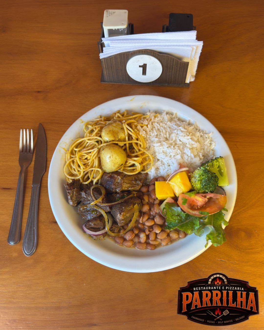Prato montado com arroz, feijão, carne, massa e salada